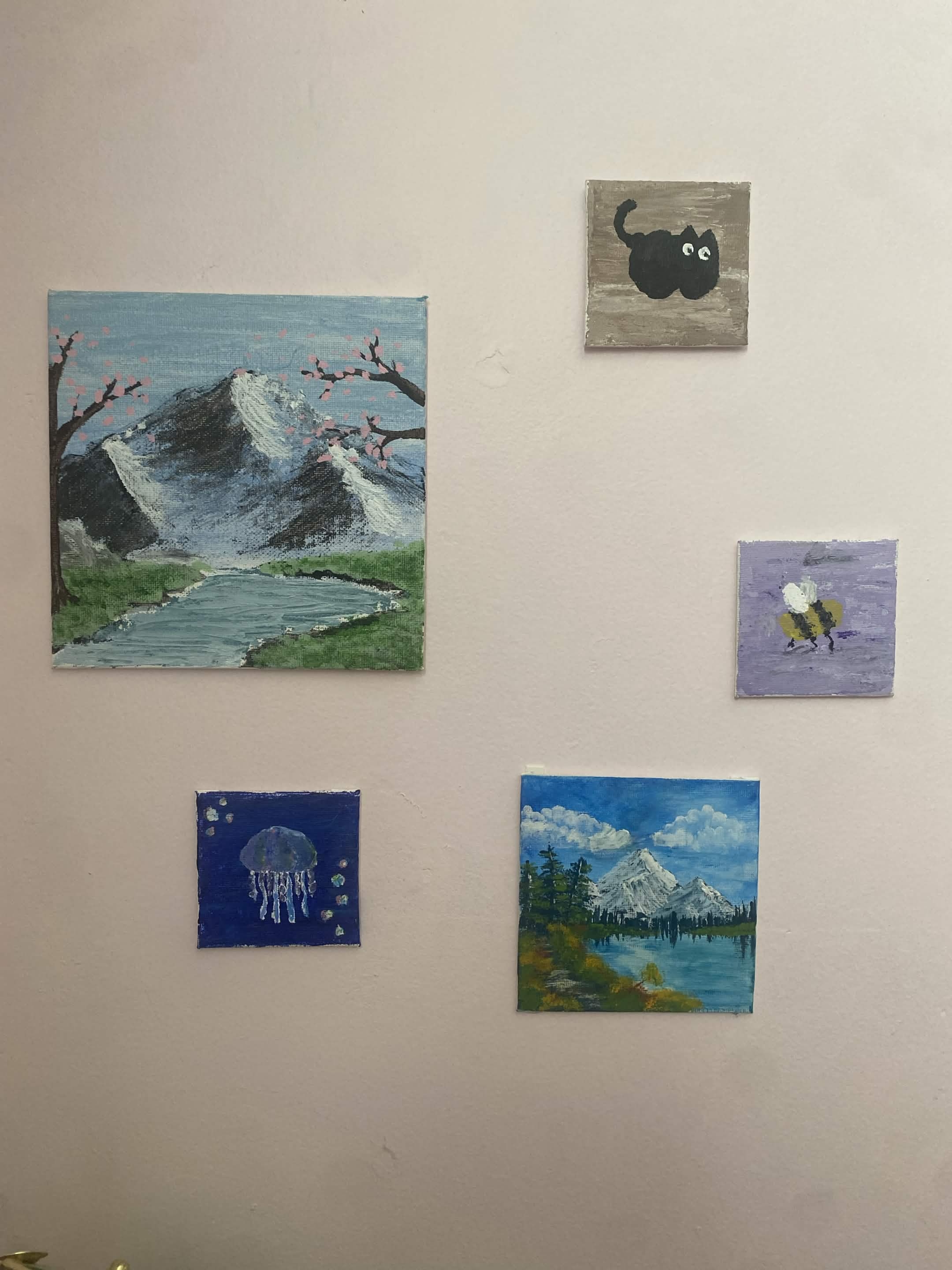 large painting of mountain and cherry tree, three small paintings showing a cat, bee and jellyfish, and on mid-sized painting showing a autum day by a mountain